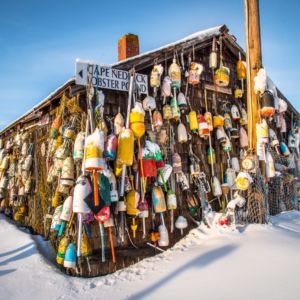 The iconic fishing shack looks nice with a fresh layer of snow and winter blue sky with the wall of lobster bouys on her siding.